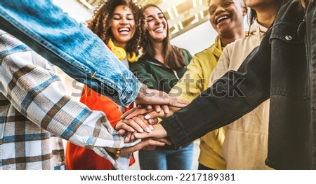 Multiracial happy young people stacking hands outside - Diverse friends unity togetherness in volunteer community - Concept about university, relationship, creative, youth and human resources	