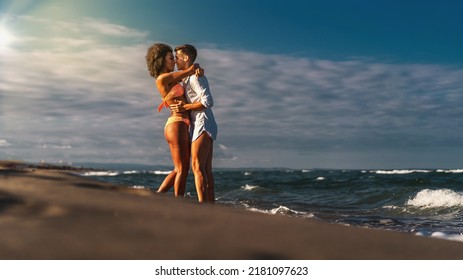 Multiracial Heterosexual Couple Kissing And Hugging On The Beach - Multiethnic Newlyweds In Honeymoon Kissing On The Beach