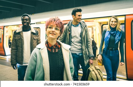 Multiracial hipster friends group walking at tube subway station - Urban friendship concept with young people having fun in city underground area - Teal and orange filter with focus on pink hair girl - Powered by Shutterstock