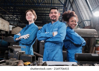 Multiracial industry workers in safety uniforms collaborate with unity, arms crossed, and express happy work together with smile and cheerful in mechanical factory, professional engineer occupation. - Shutterstock ID 2169706415