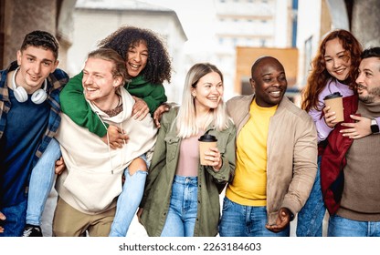 Multiracial life style concept with happy friends walking together at old town center - Young guys and girls having fun around city streets - University students on vacation day  - Bright vivid filter - Powered by Shutterstock