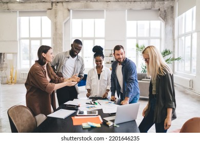 Multiracial male and female architects gathering at table with papers and gadgets while sharing ideas about new startup business plan - Shutterstock ID 2201646235