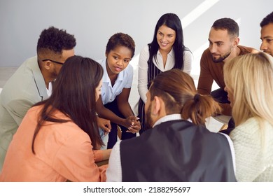 Multiracial Men And Women At Support Group Meeting Listen To Young Woman Tell Her Story. Young People Sit In Circle Talking And Listening To Each Other's Stories. Concept Of Group Therapy.