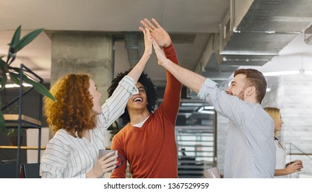 Multiracial millennial friends giving high five, enjoying coffee break time in office, panorama - Shutterstock ID 1367529959