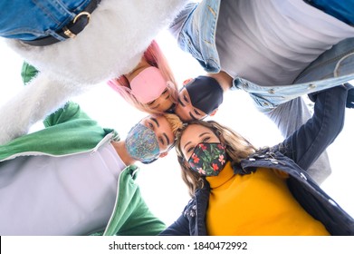 Multiracial millennial friends taking selfie smiling behind face masks - Happy friendship and new normal concept with young people having fun together outside the school - Powered by Shutterstock