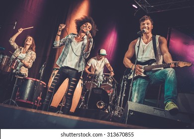 Multiracial Music Band Performing On A Stage 