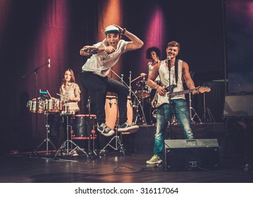 Multiracial Music Band Performing On A Stage 