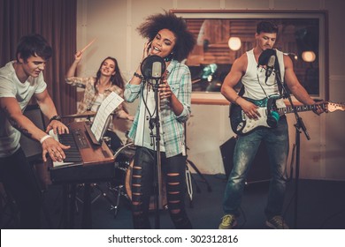 Multiracial music band performing in a recording studio  - Shutterstock ID 302312816