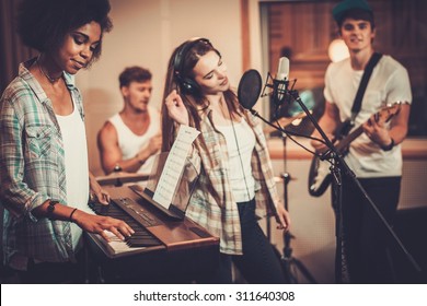 Multiracial Music Band Performing In A Recording Studio 