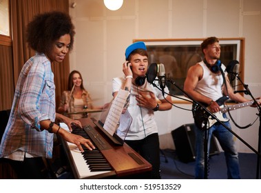 Multiracial Music Band Performing In A Recording Studio