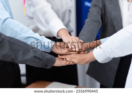 Multiracial office worker's hand stack shows solidarity, teamwork and trust in diverse community. Businesspeople unite for business success through synergy and collaboration by hand stacking. Concord