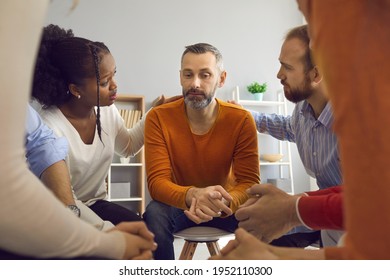 Multiracial People Communicate And Support Each Other In Group Therapy Session. Patients Comforting And Reassuring Upset Unhappy Mature Man. We're Here For You With Honesty, Compassion And Empathy