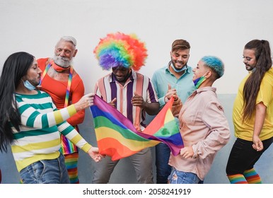 Multiracial People Dancing At Lgbt Pride Parade With Rainbow Flag While Wearing Safety Mask Under Chin For Coronavirus Outbreak