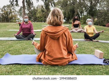 Multiracial People Doing Yoga Class Outdoor Sitting With Social Distance While Wearing Safety Mask - Coronavirus Outbreak, Sport And Healthy Lifestyle Concept