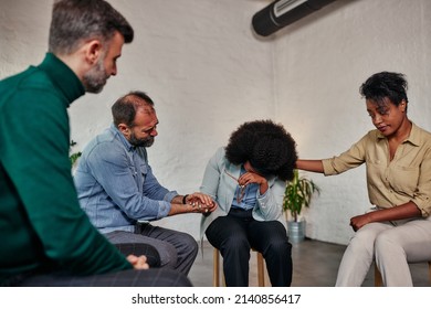 Multiracial people gathered together sitting on chairs in circle supporting crying desperate woman during group therapy session, medical detox center, psychological help assistance at meeting concept. - Powered by Shutterstock