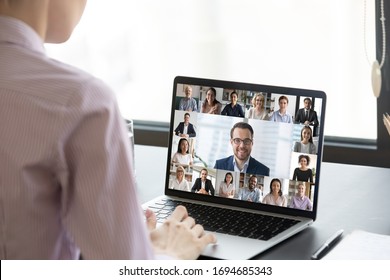 Multiracial people involved in group video call using modern tech videoconferencing application for study or business concept, view over businesswoman shoulder sitting at desk working with colleagues - Shutterstock ID 1694685343