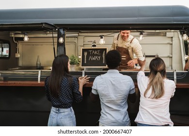 Multiracial People Ordering Food At Counter In Food Truck Outdoor - Focus On Take Away Sign