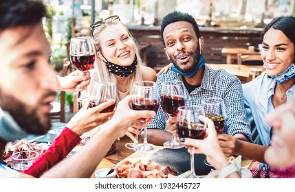 Multiracial people toasting wine at restaurant garden wearing open face mask - New normal lifestyle concept about happy friends having fun together - Bright filter with focus on guy looking at camera - Powered by Shutterstock