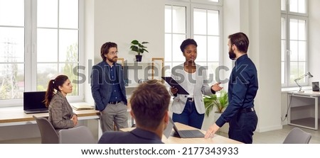 Multiracial people working in small startup or large company talking during business meeting solving organizational issues in spacious office around table. Inclusion and diversity in corporate culture