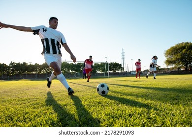 Multiracial Player Kicking Ball While Playing Soccer Match Against Clear Sky In Playground In Summer. Copy Space, Summer, Rivalry, Effort, Unaltered, Soccer, Competition And Sport Concept.