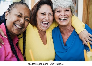 Multiracial senior friends having fun outdoor at bar restaurant - Focus on center senior face - Powered by Shutterstock