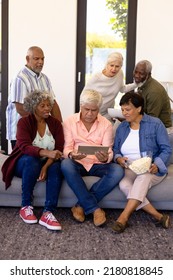 Multiracial Senior Friends With Popcorns Watching Match Over Digital Tablet In Nursing Home. Wireless Technology, Sport, Unaltered, Curiosity, Togetherness, Support, Assisted Living And Retirement.