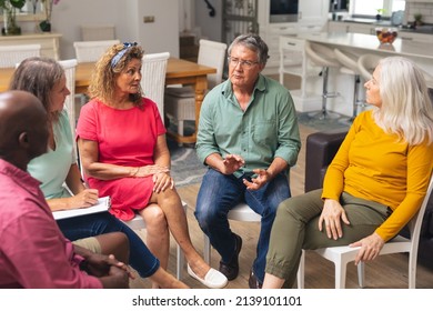 Multiracial Senior Men And Women Discussing During Group Therapy Session. Unaltered, Support, Alternative Therapy, Community Outreach, Mental Wellbeing And Social Gathering.