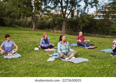 Multiracial senior people doing yoga meditation at park - Powered by Shutterstock