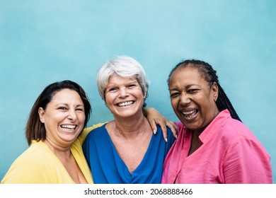 Multiracial senior women having fun hugging together outdoor - Focus on center woman face - Powered by Shutterstock