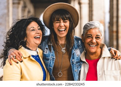 Multiracial senior women having fun together outdoor at city street- three happy mature trendy female friends hugging and laughing on urban place- Friendship lifestyle concept with elderly people - Powered by Shutterstock