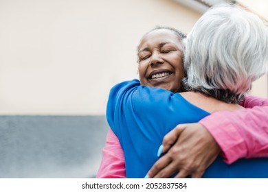 Multiracial senior women hugging each other - Elderly friendship and love concept - Focus on african woman face - Powered by Shutterstock