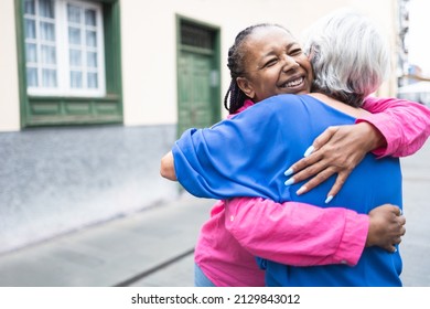 Multiracial senior women hugging each other - Elderly diverse community concept - Focus on african female face - Shutterstock ID 2129843012