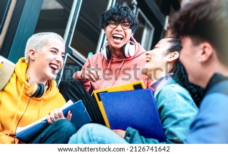 Multiracial students having fun together sitting outside school - Happy best friends enjoying time in college campus - Youth lifestyle and scholarship concept