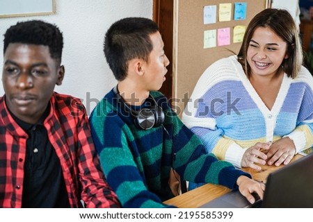 Multiracial students using laptop computers while studying at school - Focus on right girl face