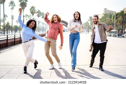 Multiracial students walking at Barcelona waterfront on funny moves - Cool guys and girls having fun together on party mood at college project - Travel vacations life style concept - Bright filter - Powered by Shutterstock