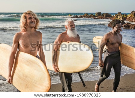 Multiracial surfer men on the beach - Multi generational people and extreme sport concept