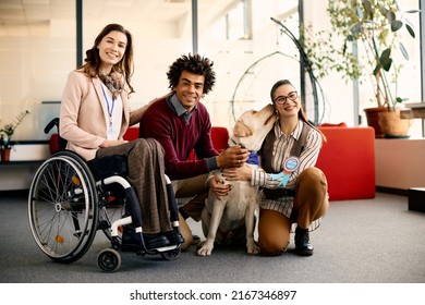 Multiracial team of business people with assistance dog at corporate office looking at camera. One of them is in a wheelchair. - Powered by Shutterstock