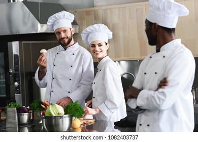 Multiracial team of cooks choosing cooking ingredients on modern kitchen - Powered by Shutterstock