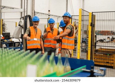 Multiracial team of industrial engineers wearing safety vests and hardhats monitoring production line of glass bottles in bottling factory, discussing and analyzing performance using digital tablet - Powered by Shutterstock