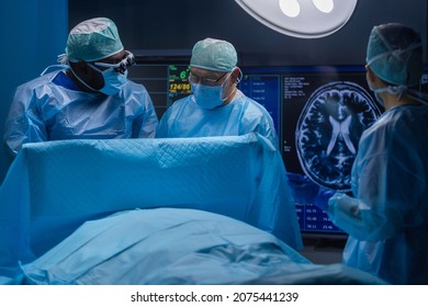 Multiracial team of professional medical surgeons performs the surgical operation in a modern hospital. Doctors are working to save the patient. Medicine, health and neurosurgery. - Powered by Shutterstock