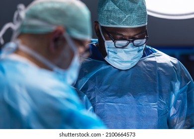 Multiracial team of professional medical surgeons performs the surgical operation in a modern hospital. Doctors are working to save the patient. Medicine, health, cardiology and transplantation. - Powered by Shutterstock