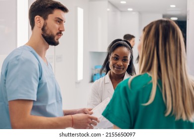 Multiracial Team Of Young Doctors Discussing A Patients Condition While Working Together In A Hospital. Health And Medicine Concept. Focus On A African American Female Surgeon.