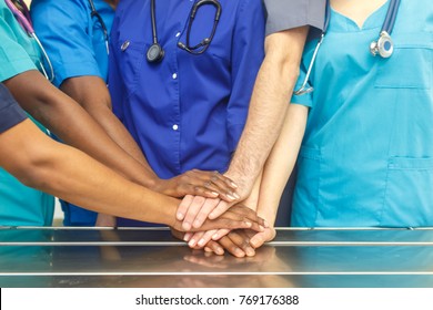 Multiracial Team Of Young Doctors Stacking Hands Indoor, Group Of Multiracial Doctor Surgery Team Stacking Hands In A Operating Room, Medical Teamwork.