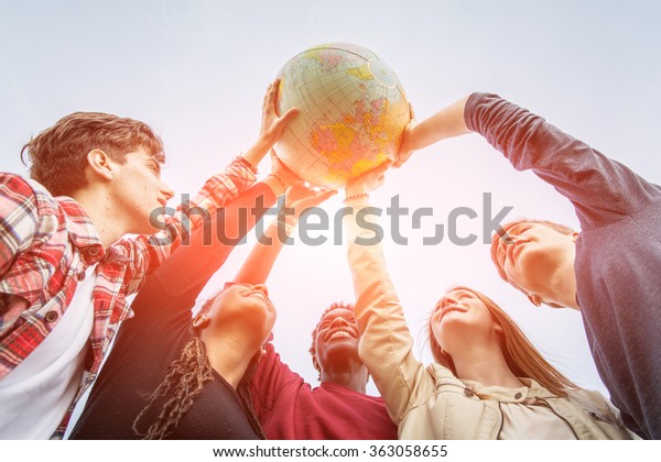 Multiracial Teen\
Couple Holding Globe Map -\
stock