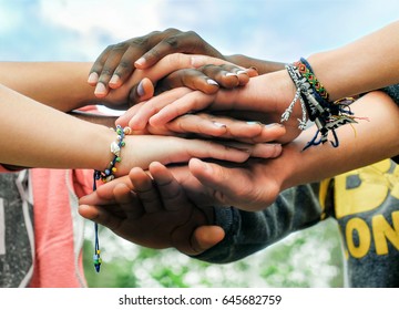 Multiracial teenagers joining hands together in cooperation - Shutterstock ID 645682759