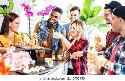 Multiracial Trendy Friends Having Fun At Fancy Dinner Party Drinking Cocktails And Eating Snacks - People Life Style Concept On Happy Hour Together At Home - Bright Vivid Filter - Focus On Blonde Girl