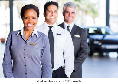 Multiracial Vehicle Sales Team Inside Car Showroom