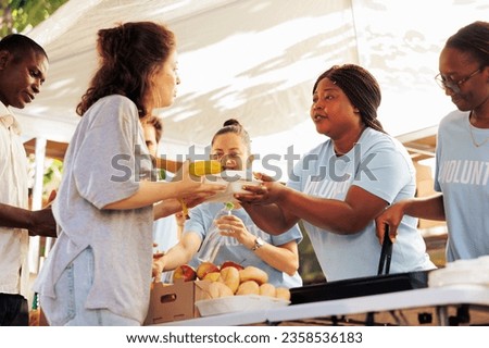 Multiracial volunteers handing out meal donations to the needy at a food drive. Image showing voluntary people generously supporting the homeless and those experiencing poverty and hunger.