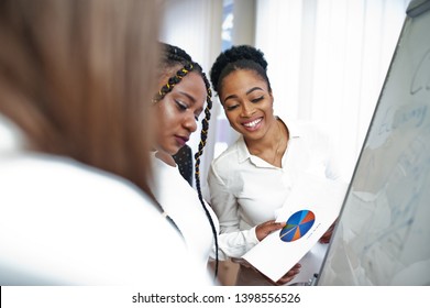 Multiracial women colleagues, crew of diversity female partners in office standing near flipchart. - Shutterstock ID 1398556526