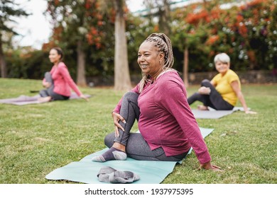 Multiracial women doing yoga exercise with social distance for coronavirus outbreak at park outdoor - Healthy lifestyle and sport concept - Shutterstock ID 1937975395